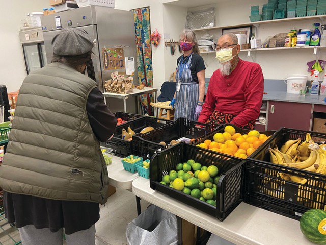 Volunteers Sally Davis and David Gee help a shopper select fresh produce on a recent Senior Saturday at the Port Townsend Food Bank. Photo courtesy of the Port Townsend Food Bank